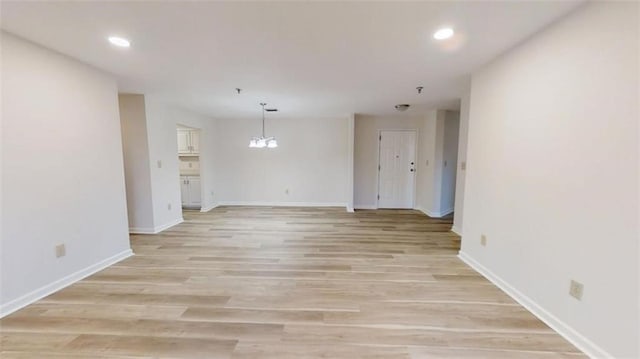 spare room with light wood finished floors, recessed lighting, and baseboards