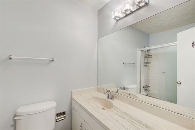 full bathroom with vanity, combined bath / shower with glass door, and toilet