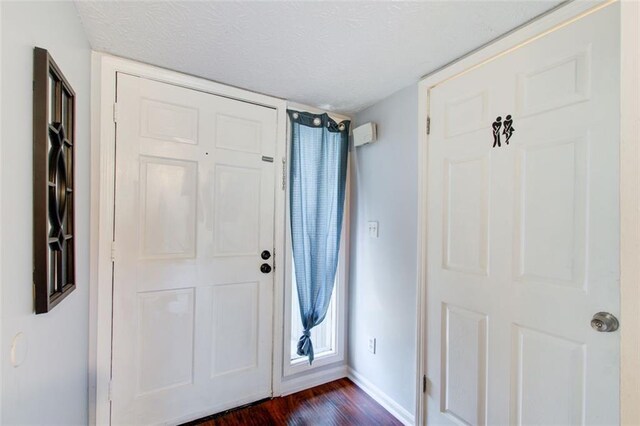 entryway with dark hardwood / wood-style floors and a textured ceiling