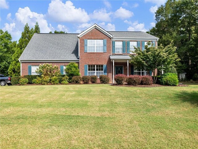 colonial inspired home featuring a front yard