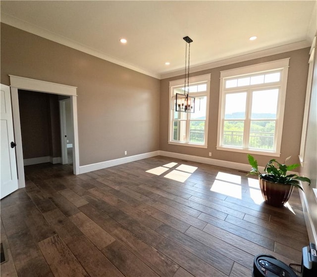 unfurnished dining area featuring dark hardwood / wood-style floors, crown molding, and an inviting chandelier