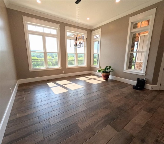 unfurnished dining area featuring dark hardwood / wood-style floors, a wealth of natural light, a chandelier, and ornamental molding