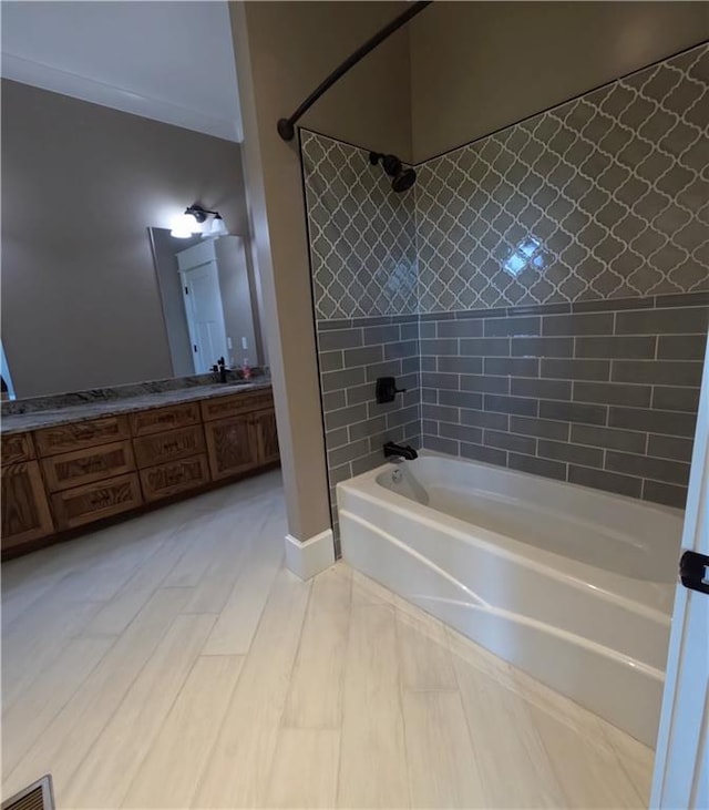 bathroom with dual vanity, tile patterned floors, and tiled shower / bath