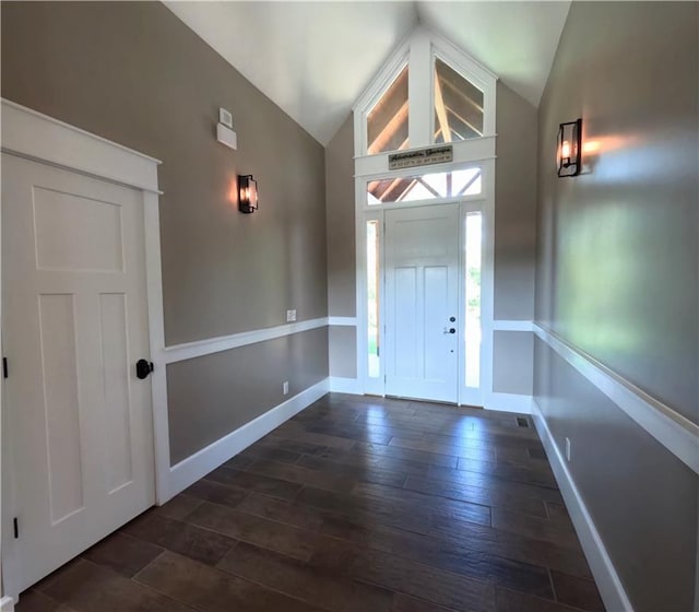 entryway with dark hardwood / wood-style flooring and vaulted ceiling