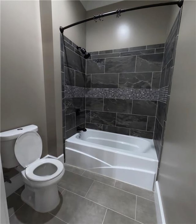 bathroom featuring tiled shower / bath combo, tile patterned flooring, and toilet