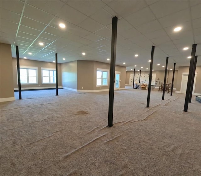 basement with light carpet and a paneled ceiling