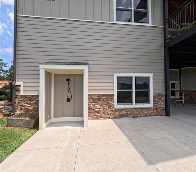 view of exterior entry featuring a balcony and a patio area