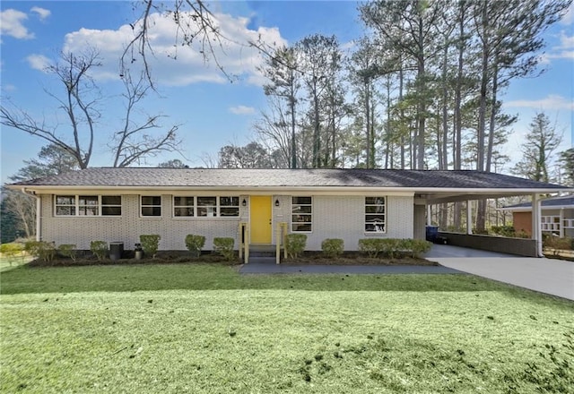 ranch-style house with a carport, brick siding, a front yard, and driveway