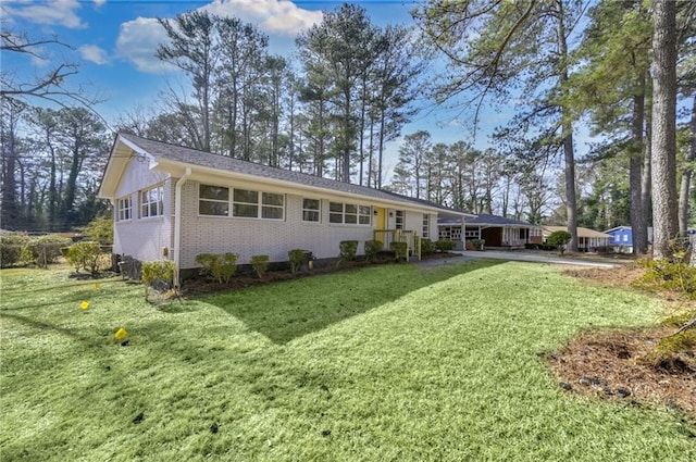 rear view of house with brick siding and a lawn