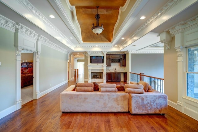 595 S Mount Carmel Rd, Mcdonough, GA 30253 - living area featuring a tray ceiling, wood finished floors, ornamental molding, a fireplace, and decorative columns
