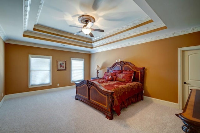 carpeted bedroom featuring a raised ceiling, ceiling fan, and ornamental molding