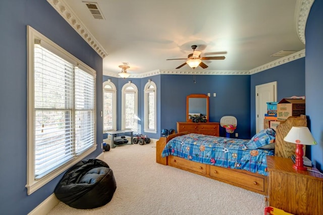 carpeted bedroom featuring multiple windows, ceiling fan, and ornamental molding