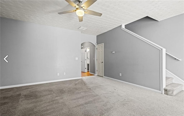 1332 Adcox Sq, Stone Mountain, GA 30088 - unfurnished living room featuring a ceiling fan, a textured ceiling, carpet flooring, arched walkways, and stairs