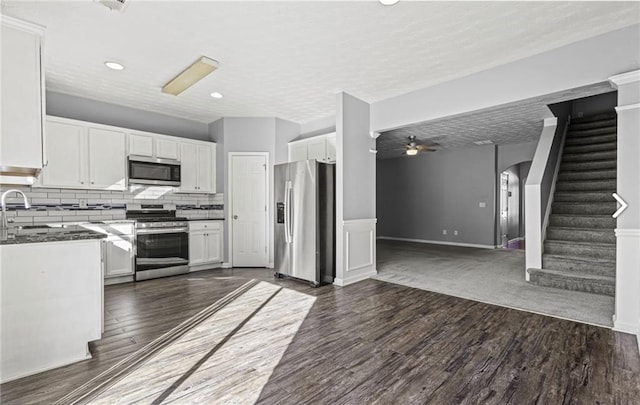 1332 Adcox Sq, Stone Mountain, GA 30088 - kitchen featuring stainless steel appliances, white cabinets, dark wood-style floors, tasteful backsplash, and ceiling fan