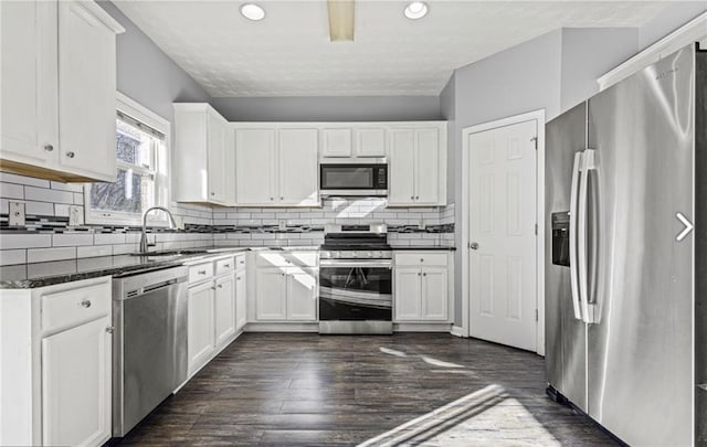 1332 Adcox Sq, Stone Mountain, GA 30088 - kitchen with appliances with stainless steel finishes, a sink, white cabinets, tasteful backsplash, and recessed lighting