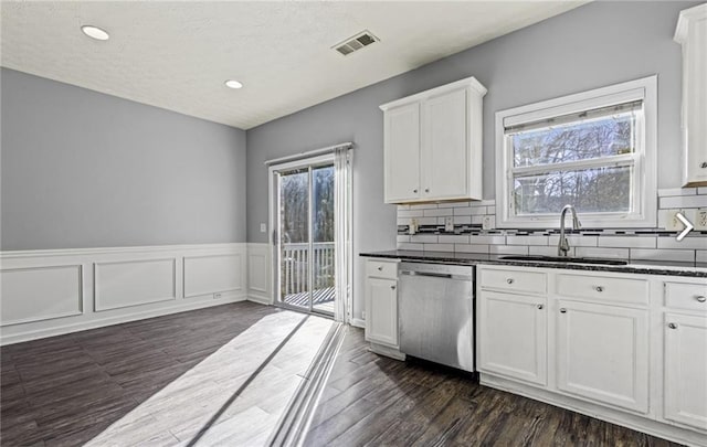 1332 Adcox Sq, Stone Mountain, GA 30088 - kitchen with stainless steel dishwasher, a sink, white cabinets, dark wood-style flooring, and recessed lighting