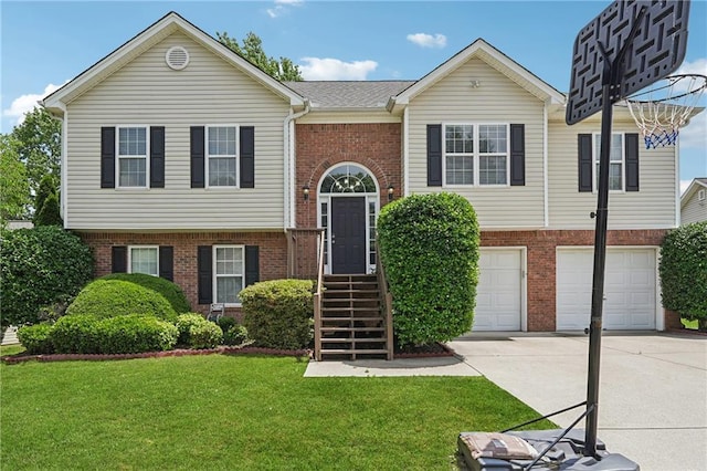 split foyer home featuring brick siding, driveway, an attached garage, and a front lawn