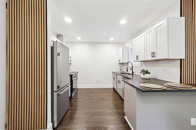 kitchen with dark wood-type flooring, sink, decorative backsplash, white cabinetry, and stainless steel appliances