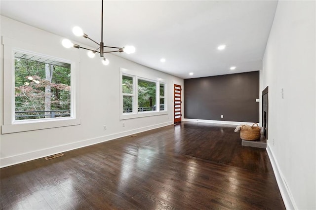 unfurnished living room with a chandelier and wood-type flooring