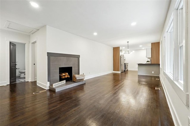 unfurnished living room featuring dark hardwood / wood-style floors, a fireplace, and a wealth of natural light