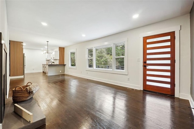 living room featuring dark hardwood / wood-style flooring and an inviting chandelier