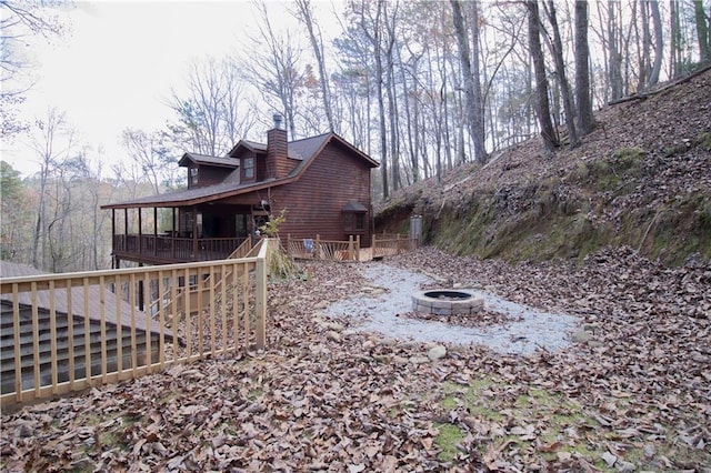 exterior space featuring a deck and an outdoor fire pit