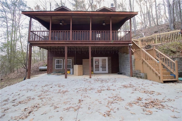 rear view of property featuring a wooden deck and french doors