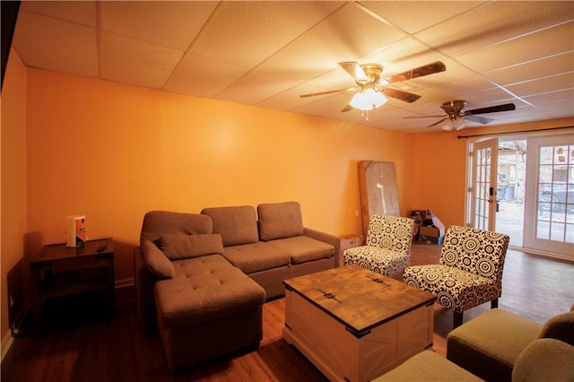 living room featuring hardwood / wood-style floors, ceiling fan, and a paneled ceiling