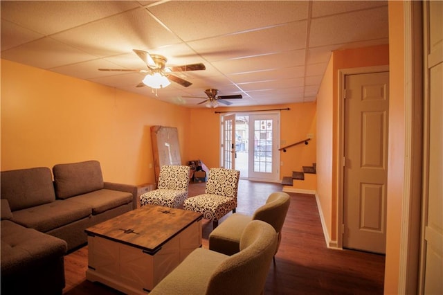 living room featuring a paneled ceiling, ceiling fan, and dark hardwood / wood-style flooring