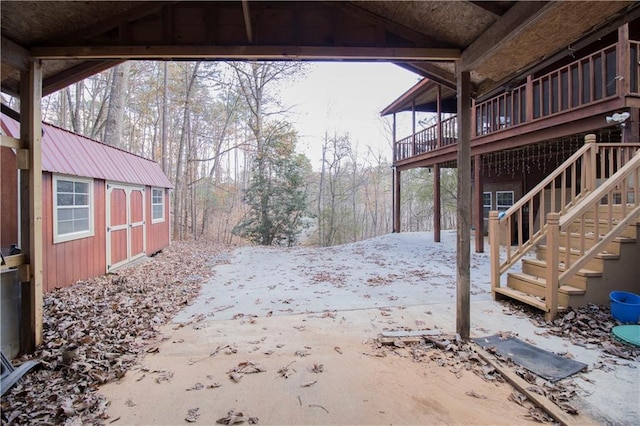 snowy yard featuring an outdoor structure and a deck