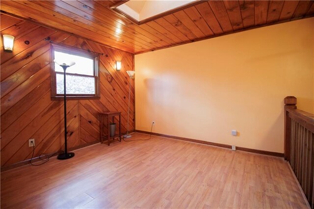 bonus room with light hardwood / wood-style floors, a skylight, wooden walls, and wood ceiling