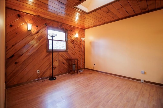 additional living space with a skylight, wooden walls, wooden ceiling, and wood-type flooring