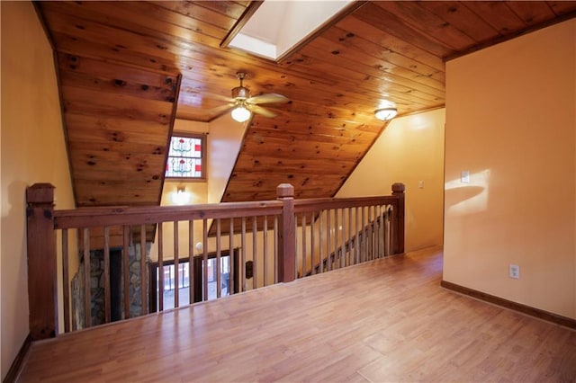 additional living space featuring ceiling fan, vaulted ceiling with skylight, wooden ceiling, and hardwood / wood-style flooring