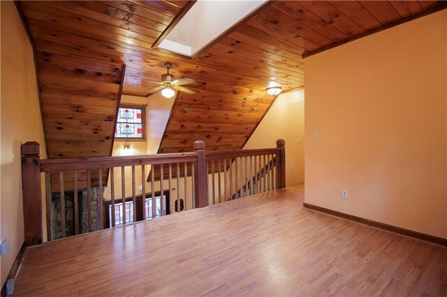 additional living space featuring hardwood / wood-style floors, ceiling fan, vaulted ceiling with skylight, and wood ceiling