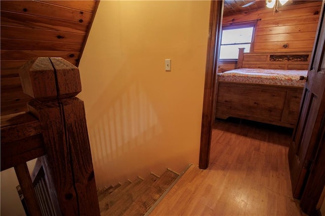 hall featuring wooden walls, wooden ceiling, and light wood-type flooring