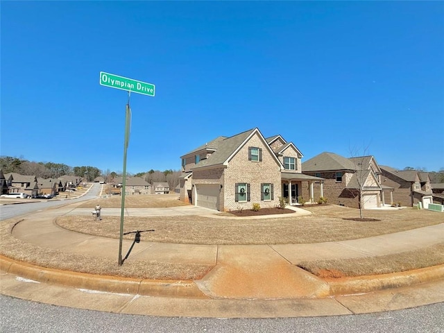 view of front facade with brick siding, a residential view, a garage, and driveway