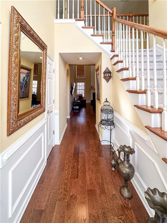 entryway with dark hardwood / wood-style floors and a towering ceiling