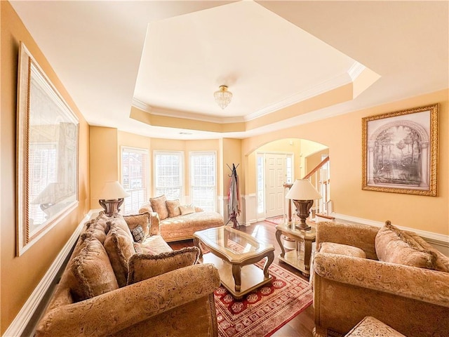 living room with a raised ceiling, ornamental molding, and hardwood / wood-style flooring