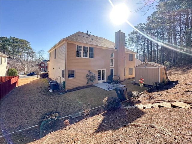 back of house with cooling unit, a patio area, and a storage unit