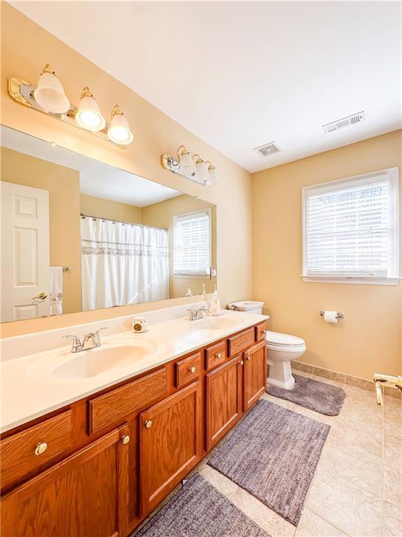 bathroom featuring tile patterned flooring, vanity, and toilet