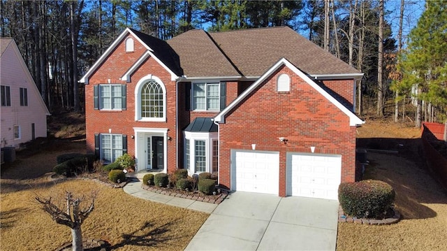 view of front of property featuring a garage and cooling unit