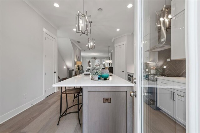 4200 Legacy Ln Unit 22, Acworth, GA 30101 - kitchen featuring a chandelier, a kitchen bar, tasteful backsplash, light wood-style floors, and a large island