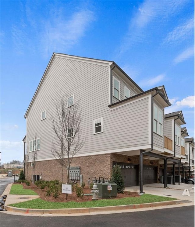 4200 Legacy Ln Unit 22, Acworth, GA 30101 - view of side of home featuring an attached garage, a carport, brick siding, and central AC unit