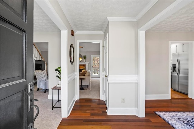 foyer with baseboards, a textured ceiling, and wood finished floors