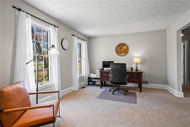 carpeted office with a textured ceiling and baseboards