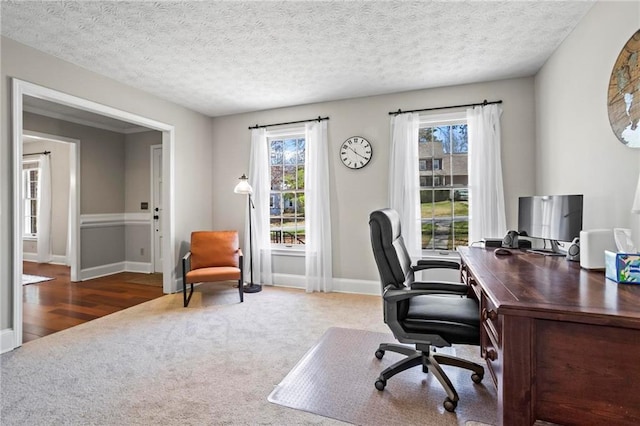 office space featuring baseboards, carpet flooring, a textured ceiling, and a wealth of natural light