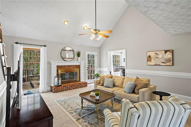carpeted living room featuring high vaulted ceiling, a fireplace, a ceiling fan, and a textured ceiling
