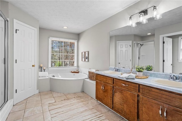 bathroom featuring a sink, tile patterned floors, a shower stall, and a garden tub