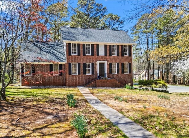 colonial inspired home featuring brick siding