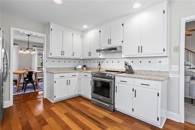 kitchen featuring stainless steel appliances, white cabinetry, wood finished floors, tasteful backsplash, and under cabinet range hood